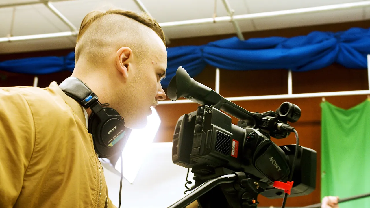 Étudiant manipulant une caméra vidéo.