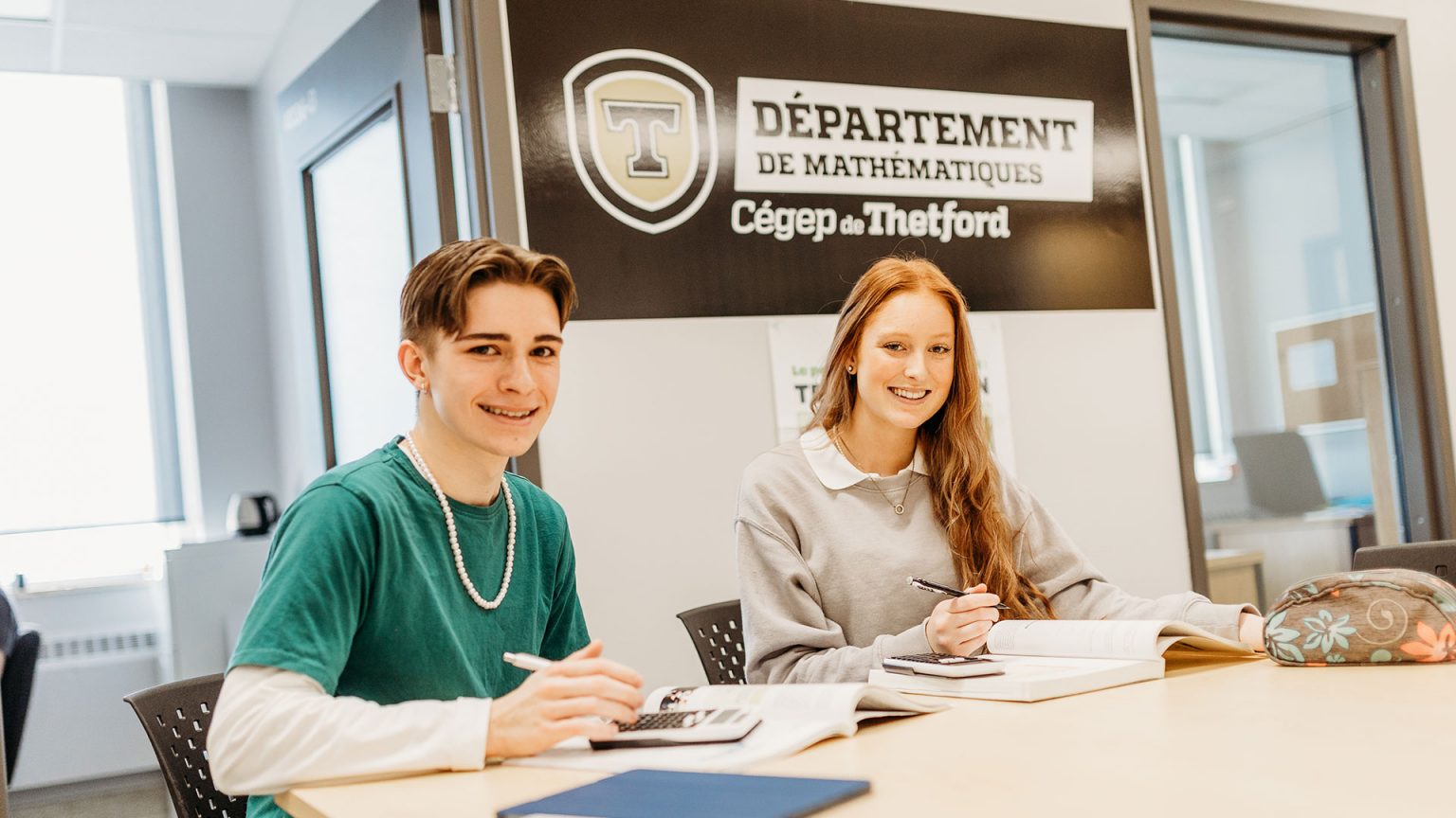 Deux étudiants souriant à la caméra dans le département de mathématiques du Cégep de Thetford.