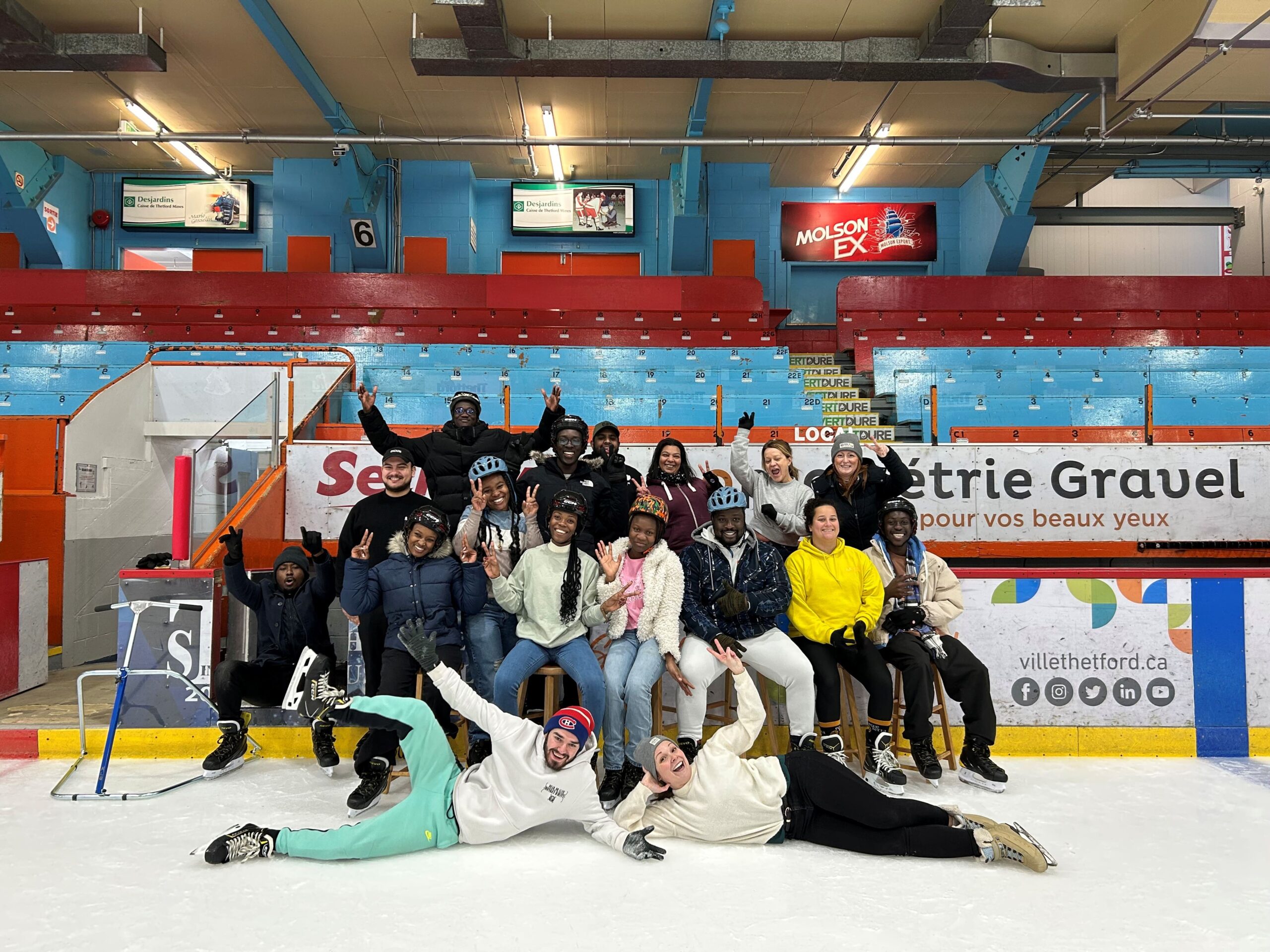 Un groupe de jeunes adultes sur une glace dans un aréna.