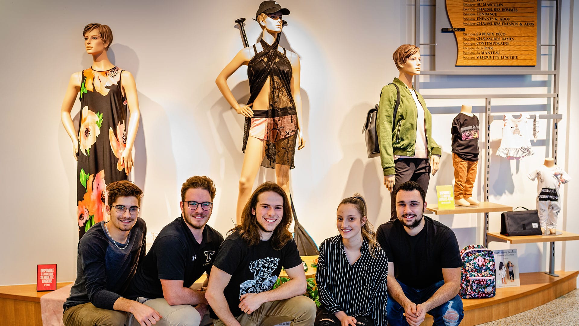 Groupe d'étudiants souriant à la caméra dans un musée.