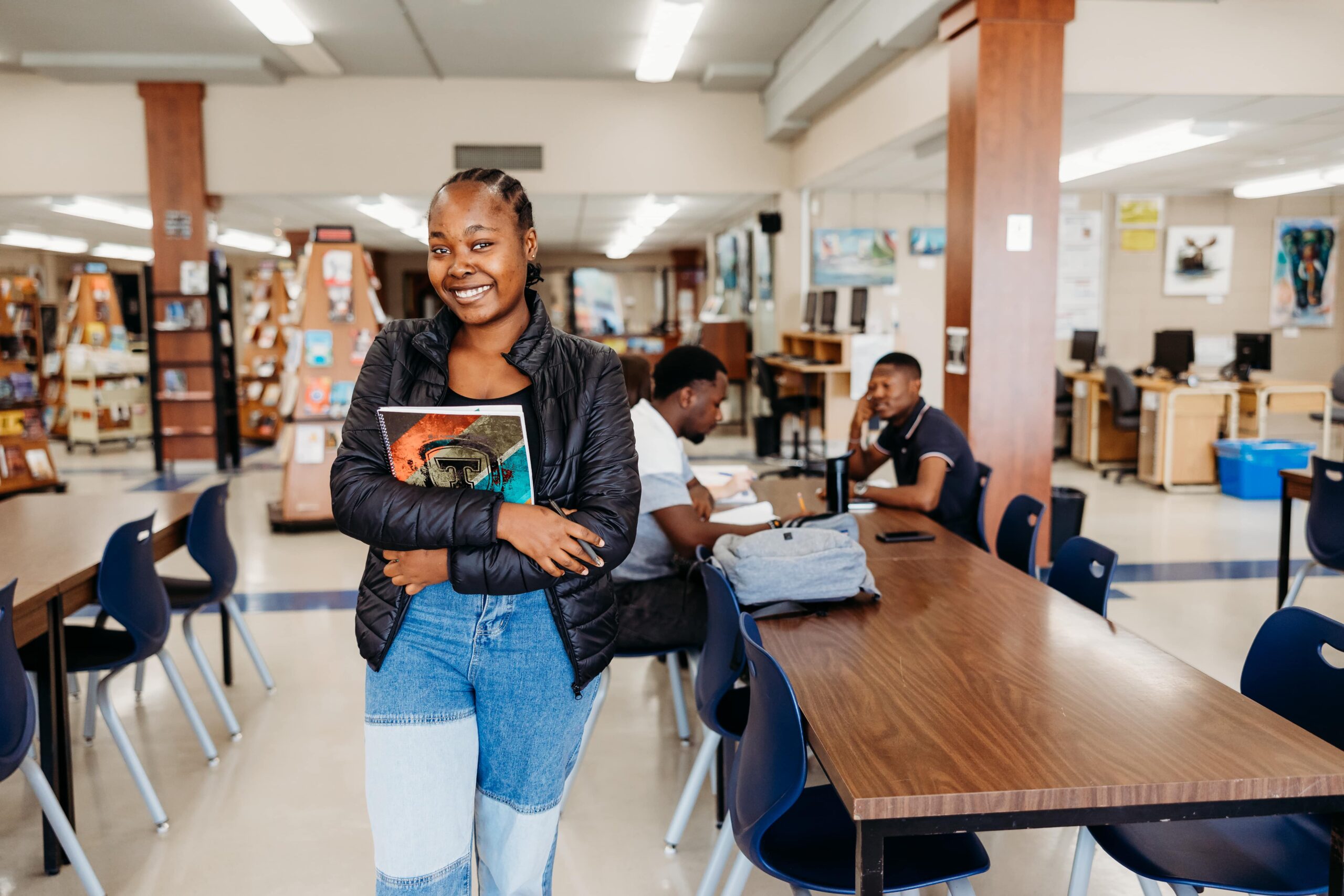 Une étudiante souriant à la caméra dans la bibliothèque du Cégep de Thetford.