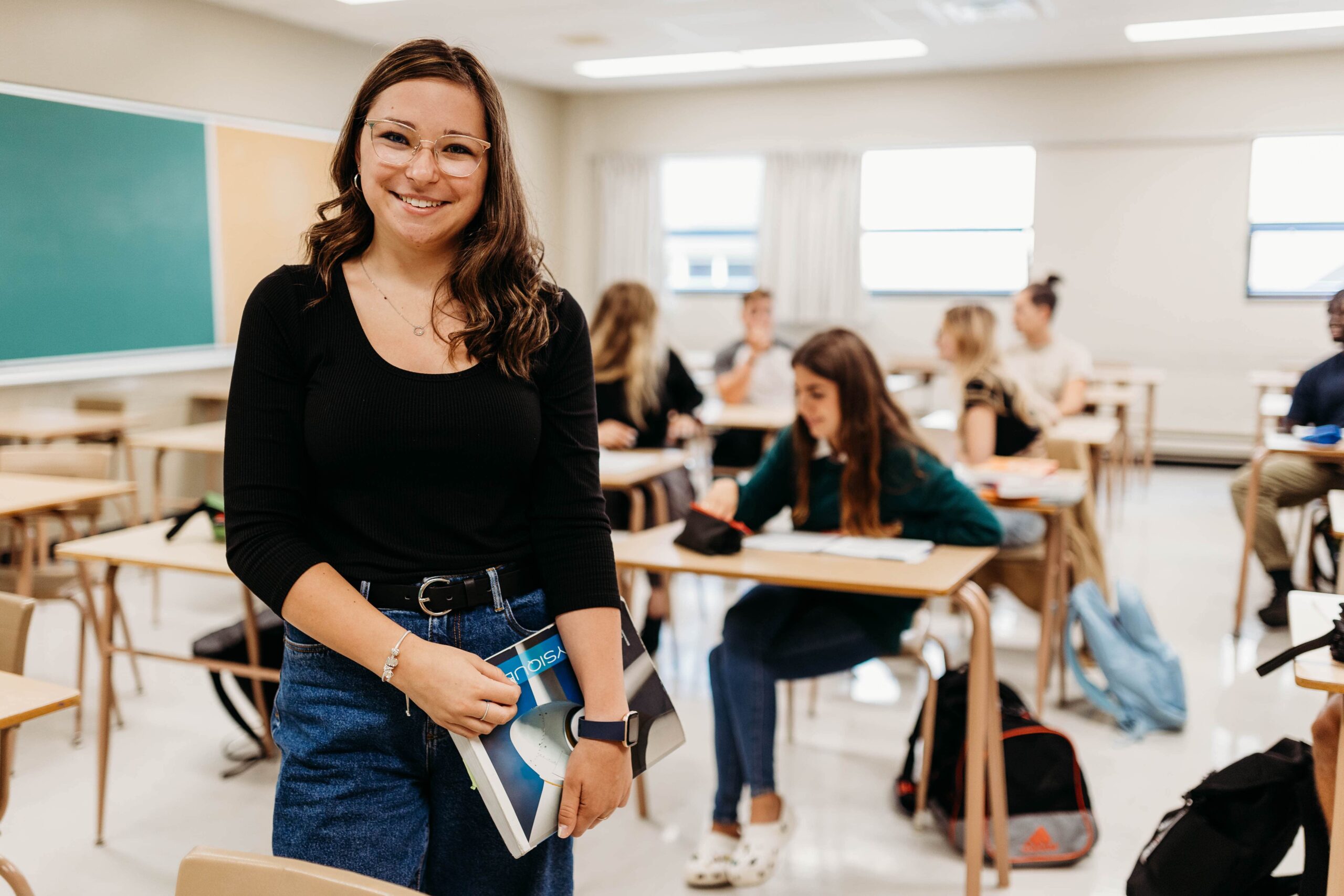 Étudiante souriante dans une classe.