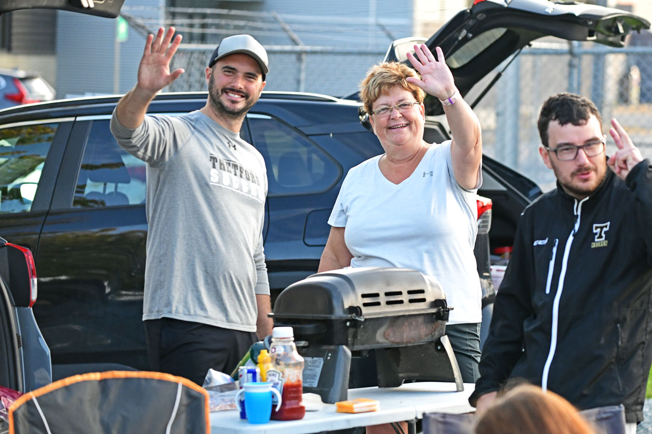 Des partisans saluent la caméra lors d'un barbecue sportif