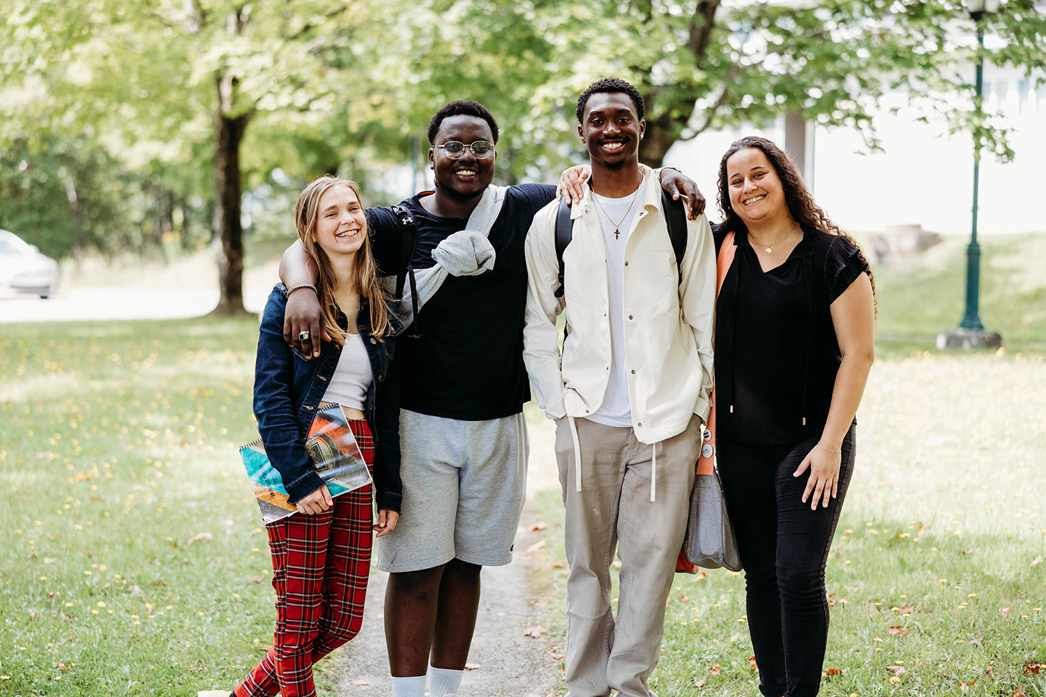 Quantre étudiants sourient à la caméra sur le campus extérieur du Cégep