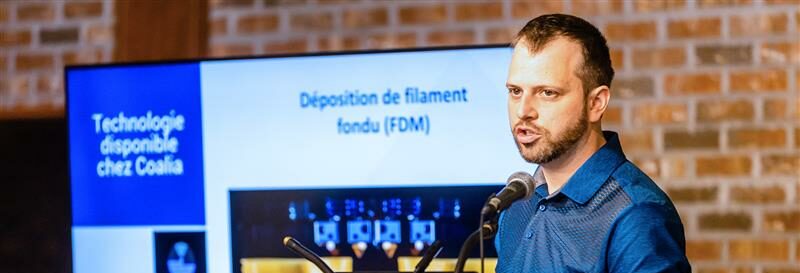 Un homme s'adresse à une salle dans le cadre d'une présentation ayant comme sujet la technologie.