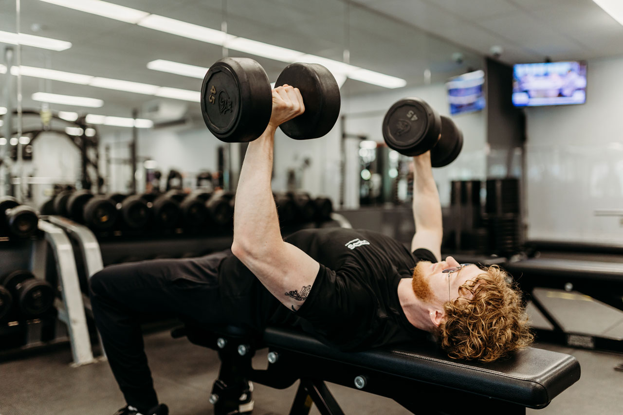 Jeune sportif pratiquant la musculation dans une salle d'entraînement