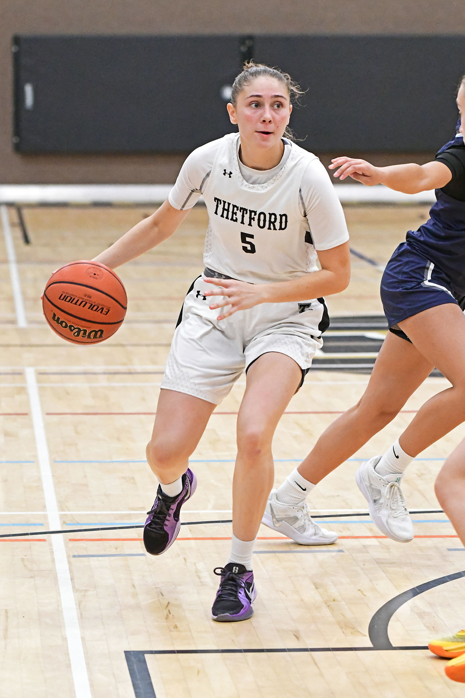Une joueuse de basketball est en mouvement.