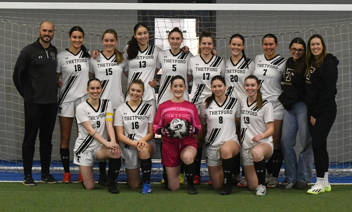 L'équipe féminine de soccer sourit à la caméra.