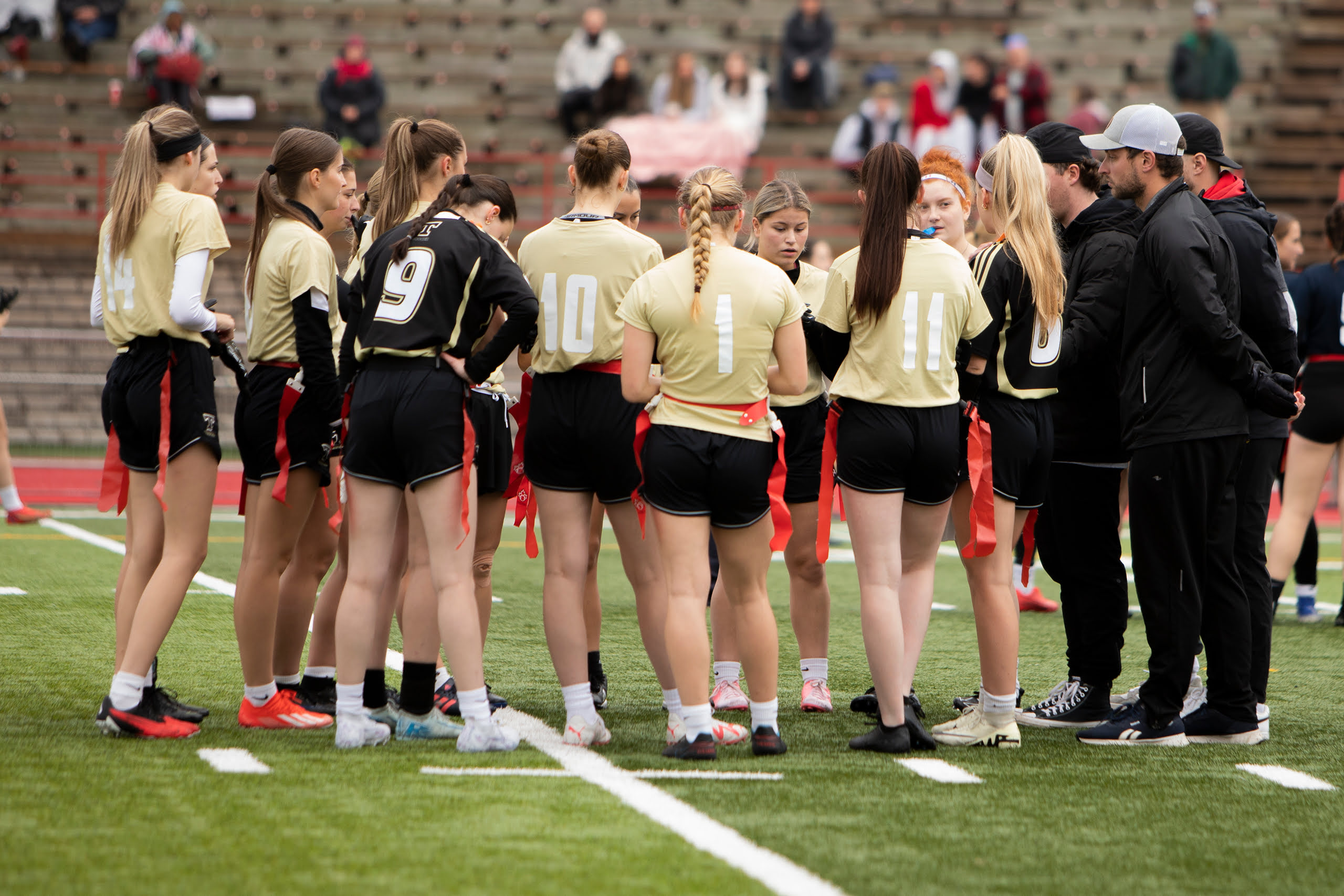 Une équipe féminine de flag-football fait un caucus.