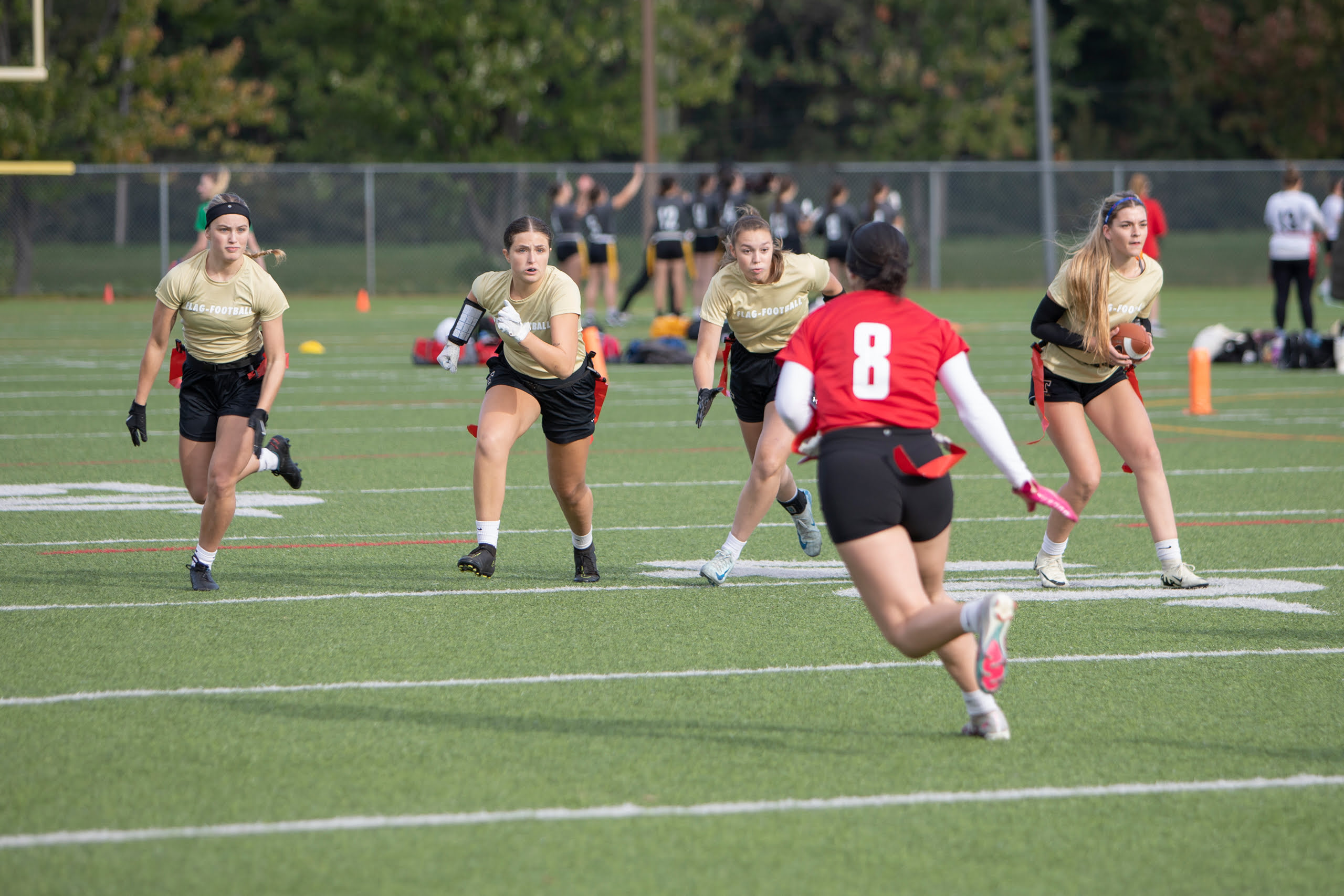 Une équipe féminine de flag-football progresse sur le terrain.