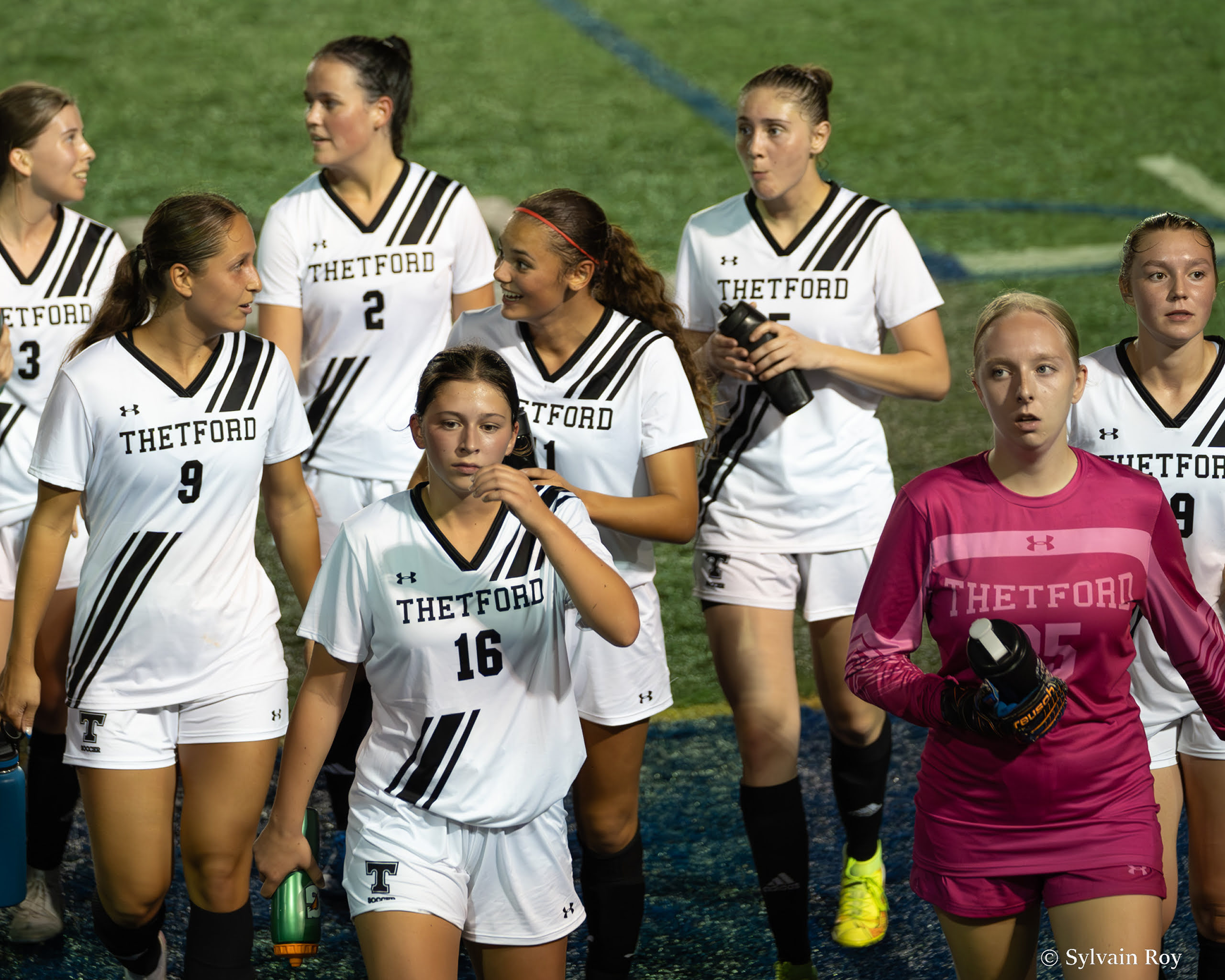 Les joueuses de l'équipe de soccer marchent sur le terrain.