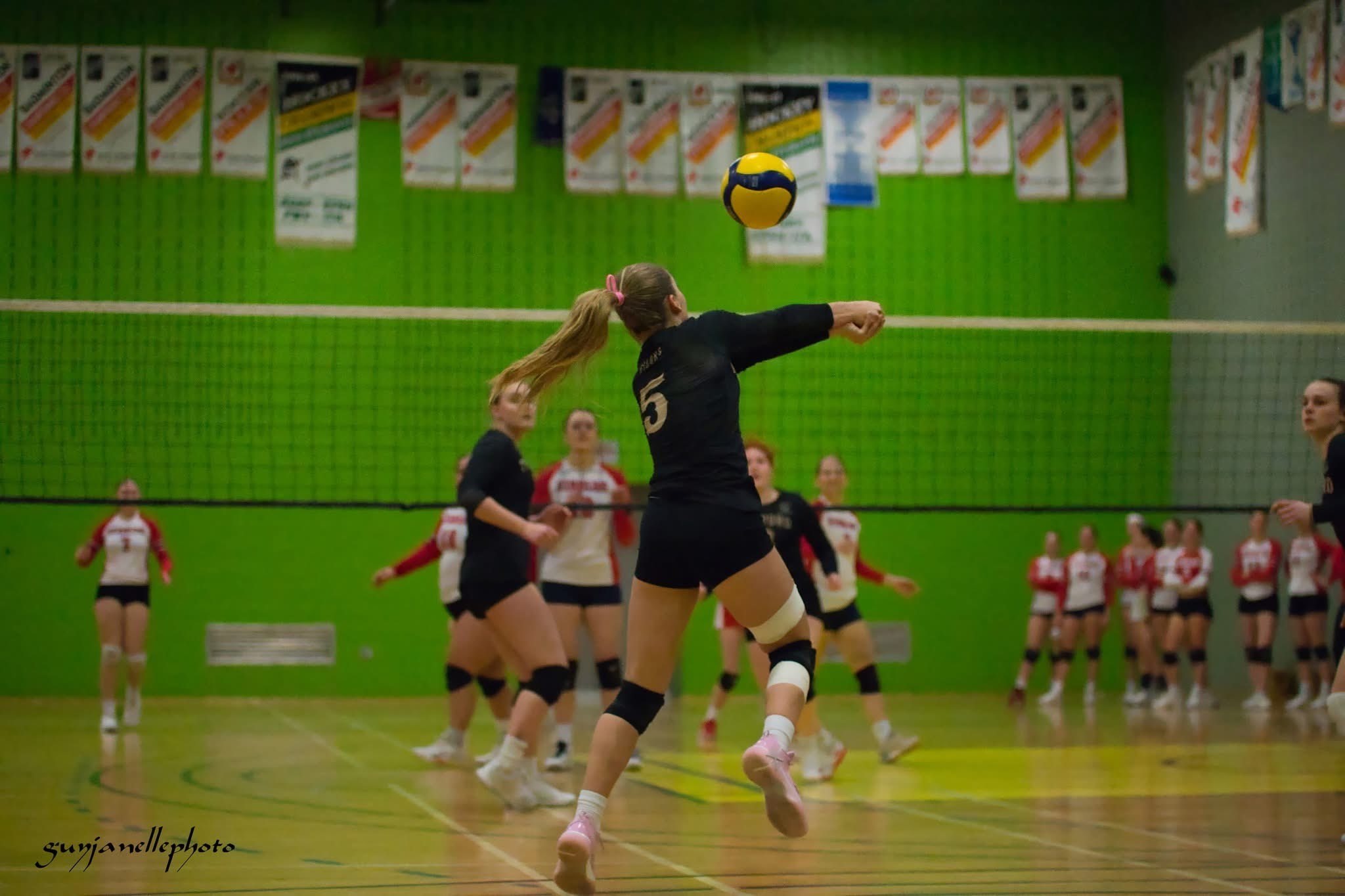Une joueuse de volleyball est sur le point de recevoir le ballon.