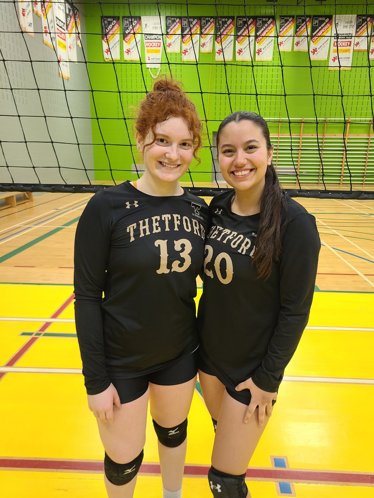 Deux joueuses de volleyball sourient à la caméra.